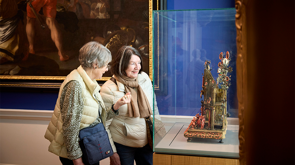 Two old friends look at an artifact in a glass case at Compton Verney Museum